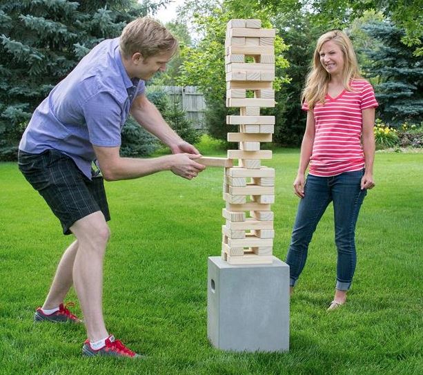 People playing giant jenga wooden stacking game outside